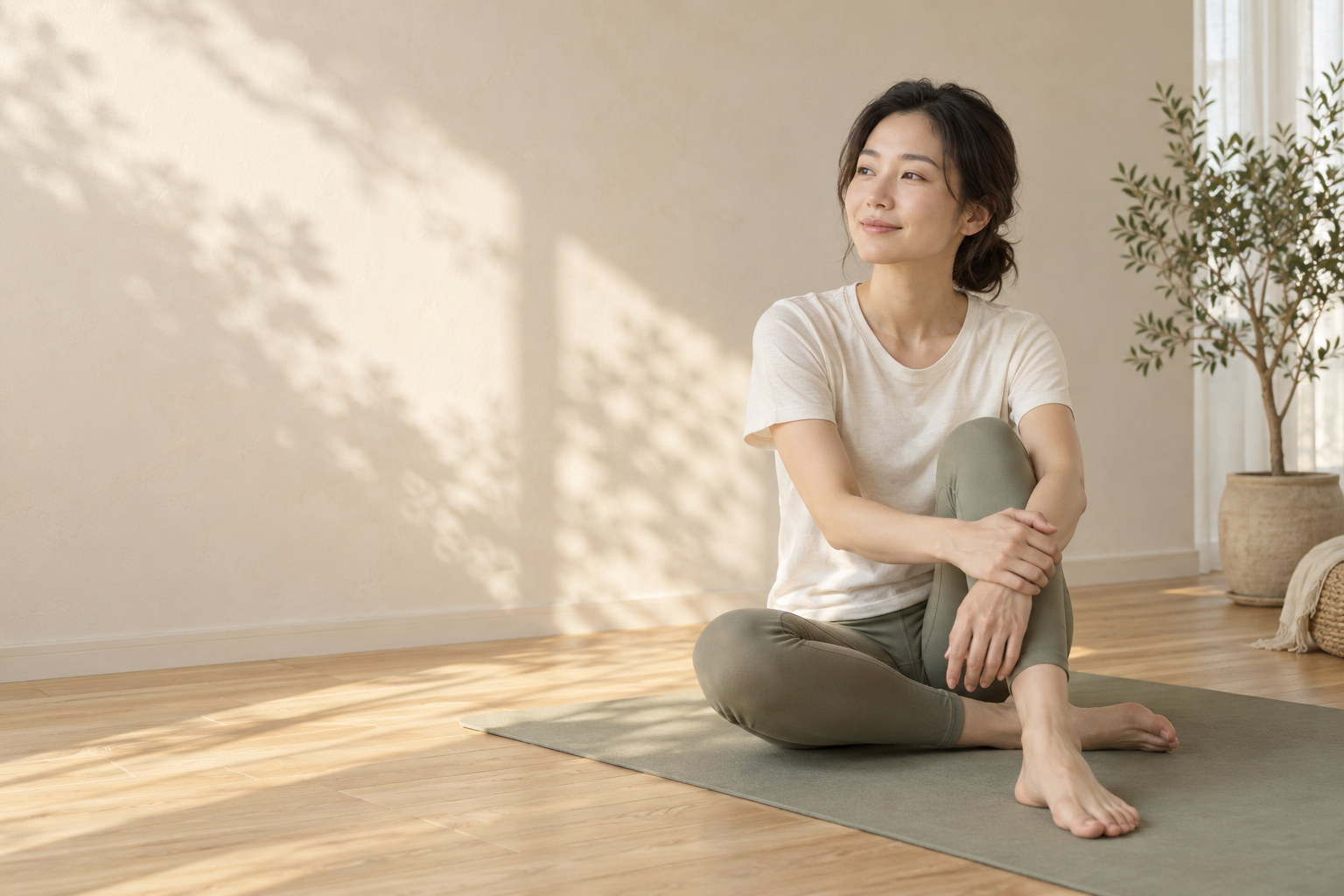 一位女性在阳光温柔的家中坐在瑜伽垫上，放松身心